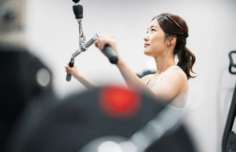 佐久市のジム「ブルーマリンスポーツクラブ佐久店」のブログアイキャッチ画像です。女性がラットプルダウンを行っている写真です。